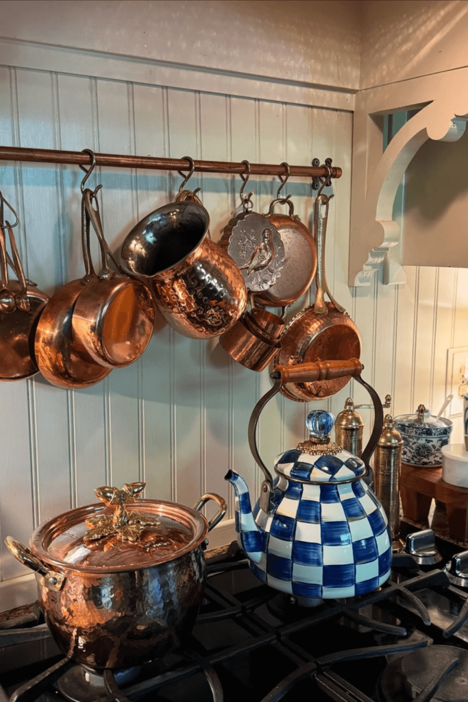 Panelas de cobre penduradas em cozinha cottagecore com charme rústico
